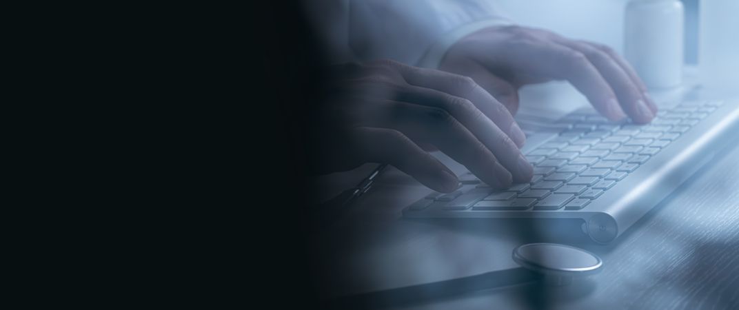 Doctor working at computer keyboard through X-ray film