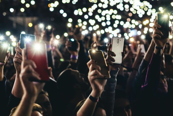Cropped image of audience holding the phones in the air